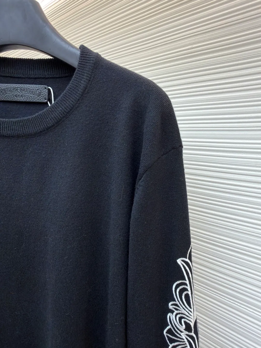 Chrome Hearts scroll embroidered sweater ●Item number: 1682476-A85 ●Fabric: wool fabric ●Technology: embroidery production ●Color: black ●Version: loose fit ●Weight: about 475 grams ●Size: S-M-L-XL ●Description: Select high-quality wool and cashmere raw materials, blended according to a certain proportion. Wool provides warmth and durability, while cashmere gives clothing a soft, delicate feel. The combination of the two makes the fabric both comfortable and practical. Different from market products, our sweaters feel softer and waxier. We use the shrinking characteristics of cashmere fiber to shrink the sweaters. Ironing knitted sweaters to make them smoother and crisper while maintaining style characteristics. The ironing process requires precise control of temperature and pressure to prevent clothing from deforming or being damaged. The overall wiring is straight and delicate, the fabric is comfortable and soft, and the color is consistent without color difference. It can be matched with the same style to create a fashionable look and control various occasions. Customized accessories, complete with three standards, same style for men and women!